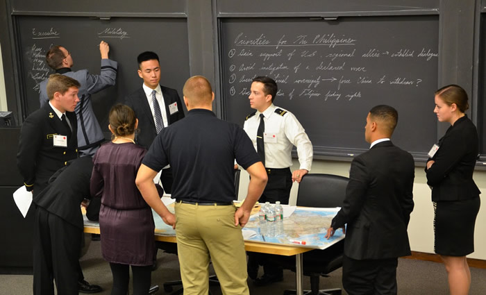 Participants standing by table and blackboard