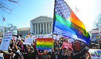 crowd in front of court house holding a rainbow American flag