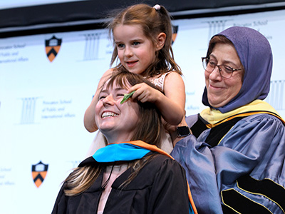 Dean Jamal hooding graduate student with child