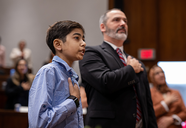 Child and adult citing the Pledge of Allegiance during ceremony