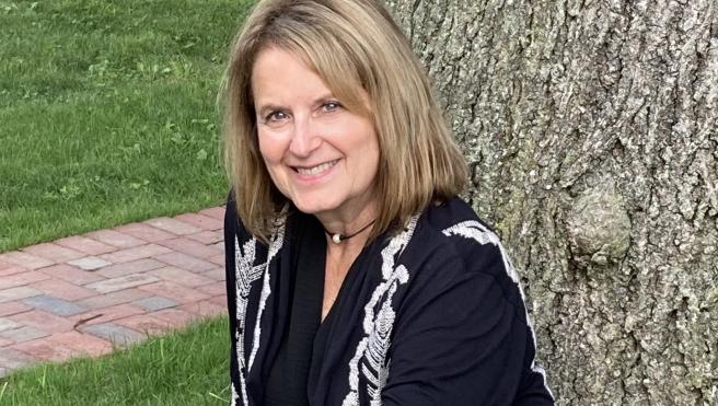 Woman sits in front of a tree