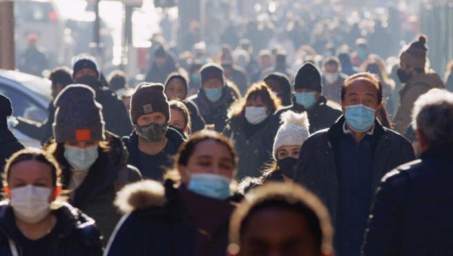 A crowd of people walking with coats