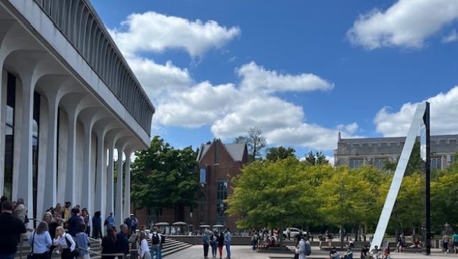 Robertson Hall with people standing in front and sky and clouds