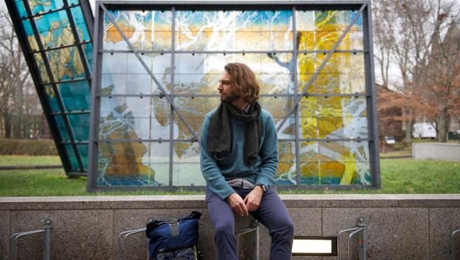 man sitting in front of a stained glass sculpture