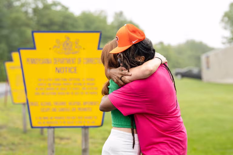 Muti Ajamu-Osagboro hugs a student from the Making an Exoneree course after his release from prison. 