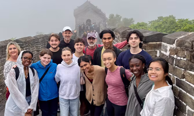 A group of people in front of the Great Wall of China