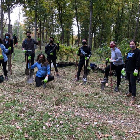 group of students leaning on shovels