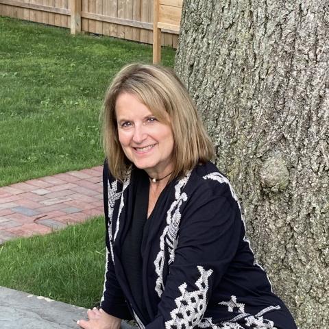 Woman sits in front of a tree