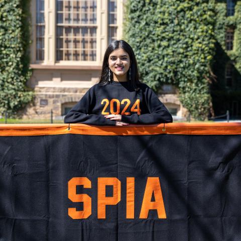 Uma Menon standing behind a SPIA banner.