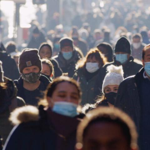 A crowd of people walking with coats