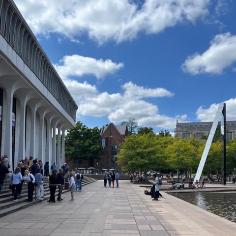 Robertson Hall with people standing in front and sky and clouds