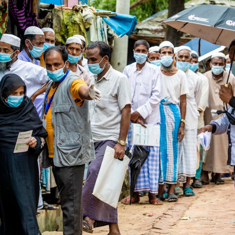 people standing in queue with face masks