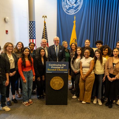 Joe Krakora, a lecturer with the Princeton School of Public and International Affairs, former New Jersey Governor Phil Murphy, Princeton SPIA Dean Amaney Jamal, and Anastasia Mann, a lecturer and the founding director of SPIA in NJ, pose with students in November 2025 during then-Governor Murphy's clemency grant announcements.