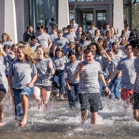 SPIA students running into Fountain of Freedom to celebrate Thesis Day. Photo credit: Andrea Kane