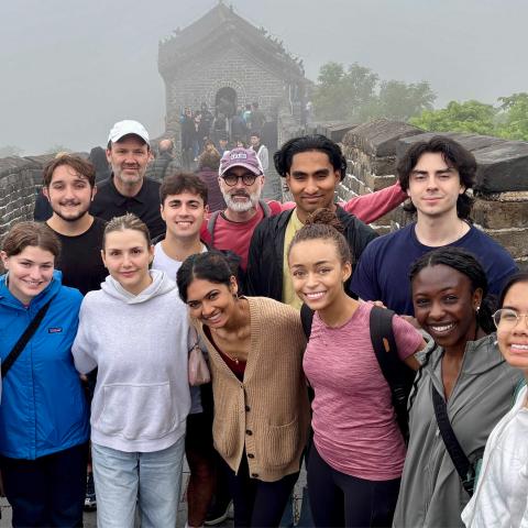 A group of people in front of the Great Wall of China