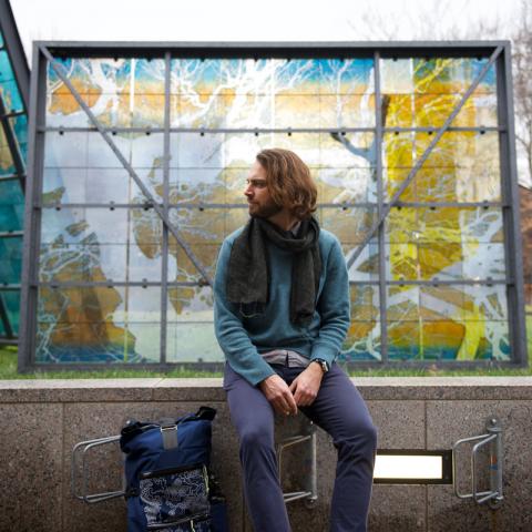 man sitting in front of a stained glass sculpture