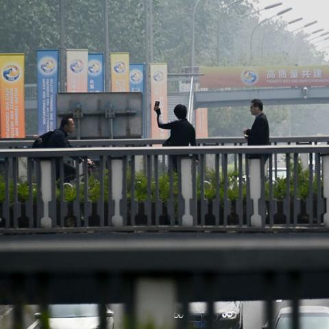 Three people on a bridge.