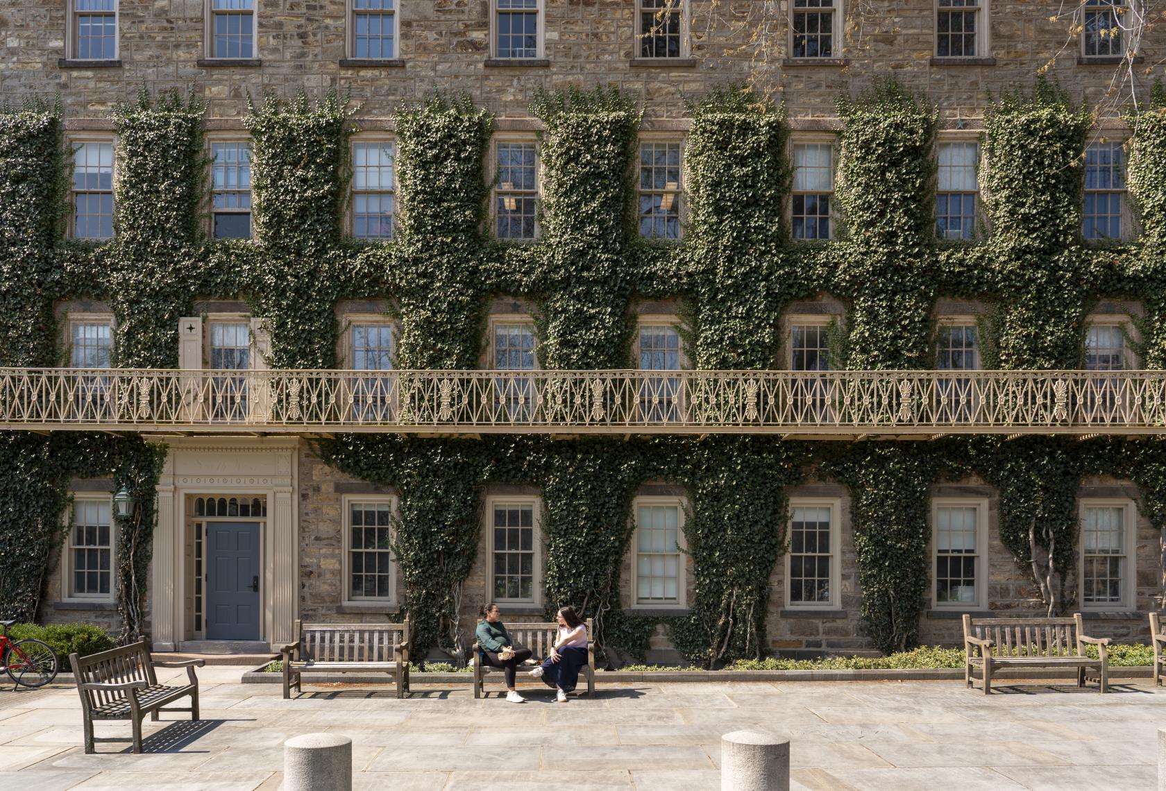 picture of Morrison Hall with students on a bench in front