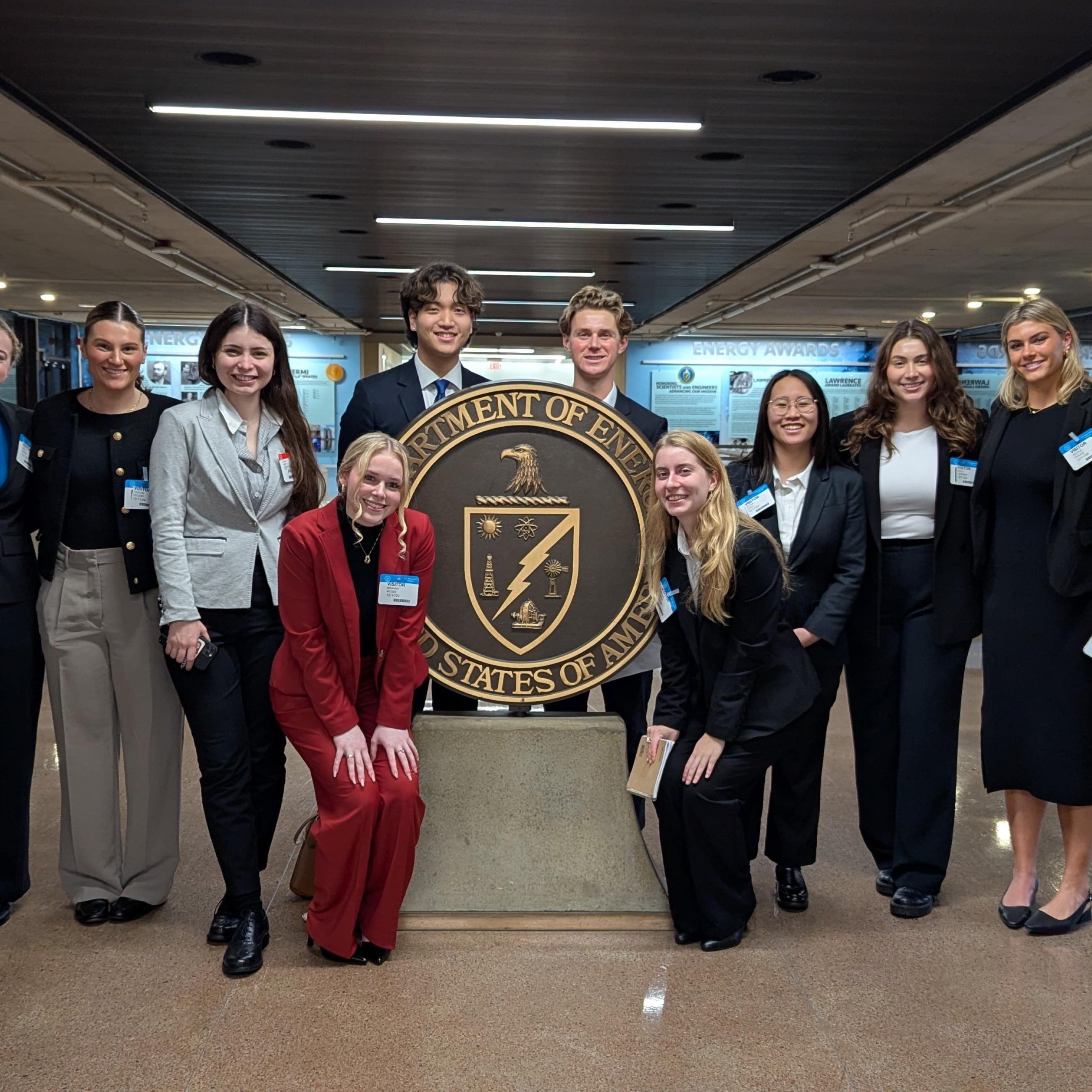 AI Task Force-students and Professor Ali Nouri posing in front of Department of Energy emblem