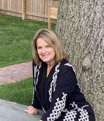 Woman sits in front of a tree