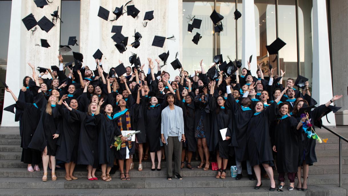 Graduating class throwing caps up in the air